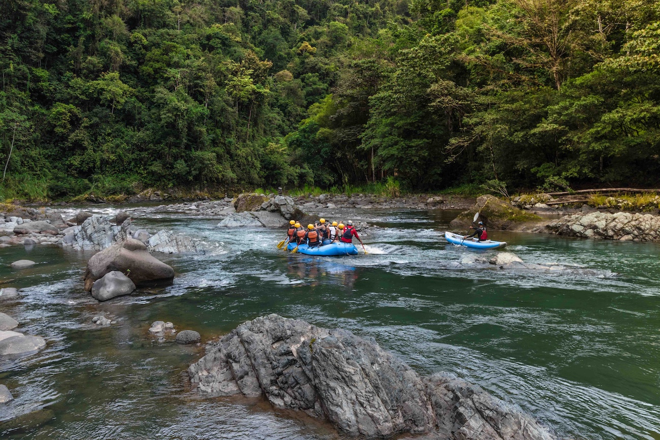 group of tourists rafting on a raft and kayak in the middle of the jungle on the Pacuare River in Costa Rica